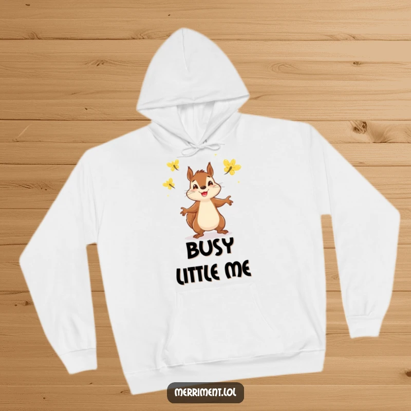 Funny hoodie depicting a determined squirrel enthusiastically juggling three luminous fireflies on a dark, cozy background.