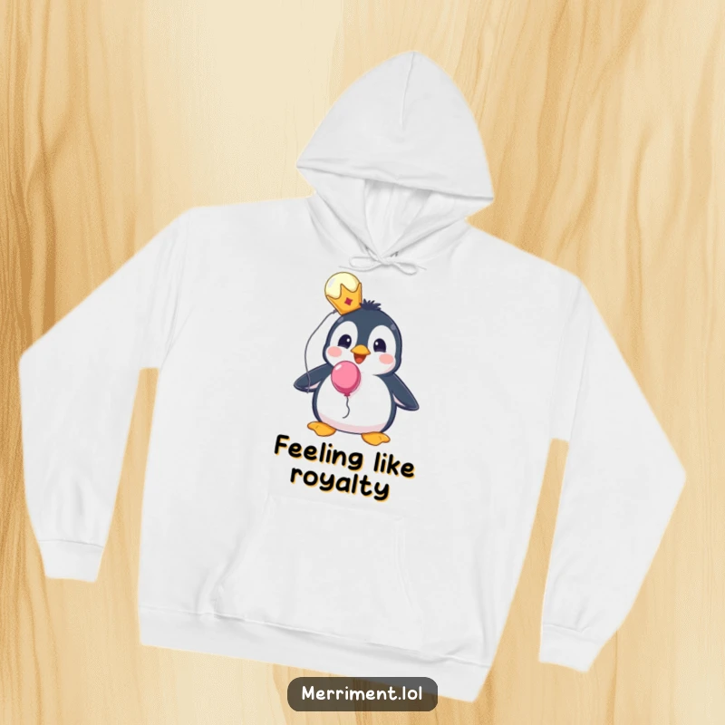 Funny hoodie featuring a surprised penguin wearing a tiny crown and holding a balloon, perfect for cozy royalty.